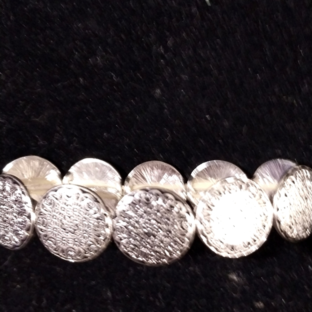 Ladies silver tone stretching bracelet. Round stamped pieces